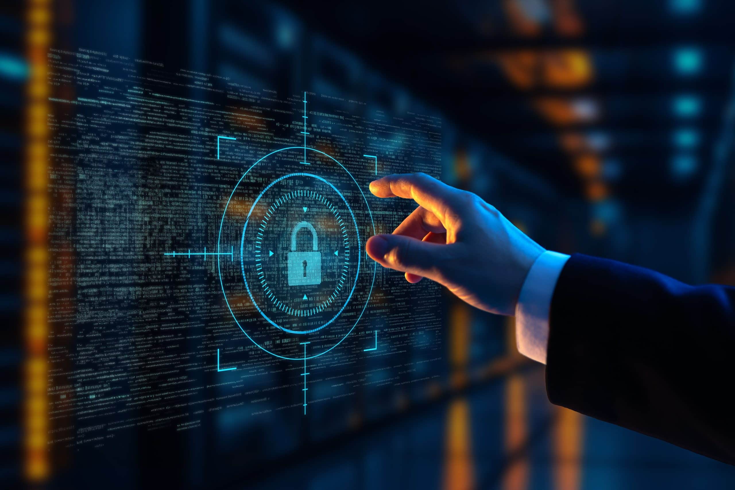 Die Hand einer Person greift nach einem leuchtenden digitalen Schlosssymbol auf einem transparenten virtuellen Bildschirm und symbolisiert die Cybersicherheit in einer hochtechnisierten, datengesteuerten Umgebung.